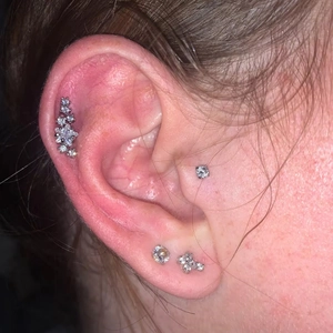 Titanium cartilage stud and labret with zircon stones shown on ear cartilage