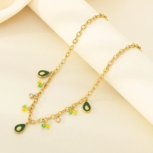 Detail of gold chain necklace with green teardrop pendants and sparkling zircons