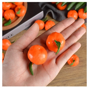 Macro shot of miniature realistic PVC oranges in a palm showing texture and leaves