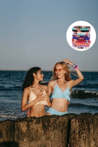 Close-up of colorful Taylor clay bead friendship bracelets worn by models at the beach