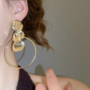 Makro-Detail von geschichteten Gold-Rundanhänger-Ohrringen mit Strass am Model