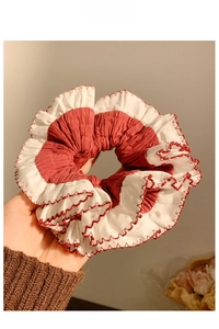 Close-up of red and white pleated hair scrunchie with dense contrast overlocked edges