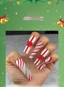 Detail of red bow and candy cane stripes on extra long coffin Christmas press-on nails