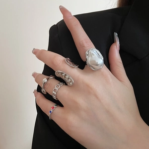 Close-up of irregular flower pea rings with pearls and zircon stones on hand