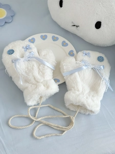 Detail of white plush mitten featuring light blue ribbon bow and lace decorative button
