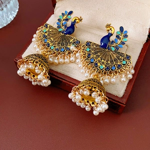 Detail view of vintage peacock earrings with blue enamel, pearls, and tassel pendant