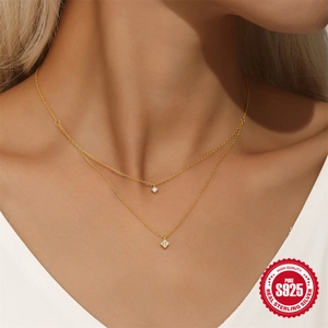 Double-layered 925 sterling silver clover necklace with gold finish on a female model