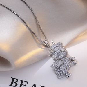 Elegant unicorn pendant necklace with sparkling white zircons on soft silk fabric