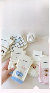 Close-up of cute cartoon cotton socks with puppy patterns and stripes on a white desk