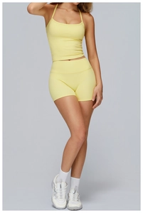 Détail d'un ensemble de yoga jaune pâle avec haut dos nu et short en tissu mat stretch
