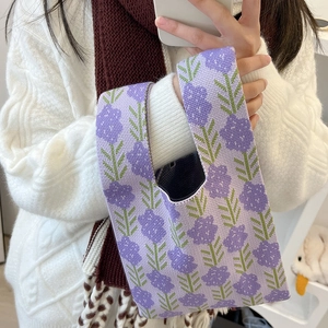 Detailed knit texture of purple floral pattern handbag with green leaf design