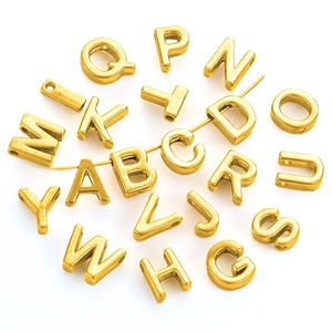 Vue macro de perles de lettres dorées en acier inoxydable de 10 mm pour bijoux DIY et colliers