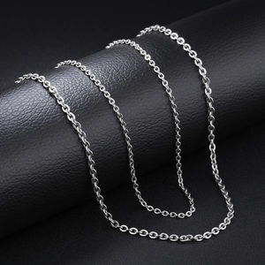Macro detail of silver-colored O-chain link necklace on black textured leather surface