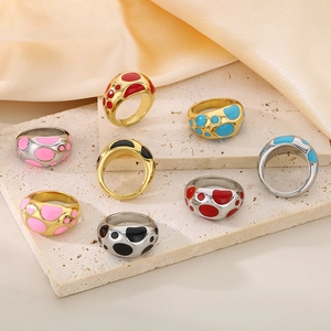 Detailed view of colorful enamel polka dot chunky rings on golden and silver metal bands