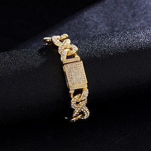 Luxurious gold plated iced out Cuban link bracelet with sparkling paved zircons on black background