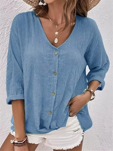 Détail de chemise bleue à col en V pour femme en coton et lin avec texture aérée
