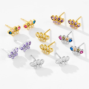 Detailed macro view of crown earrings in gold and silver with colorful zircon inlay