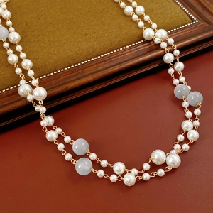 Detail of vintage double-layer necklace with white pearls and blue glass beads on leather