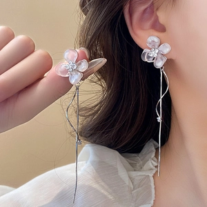Close-up of elegant flower tassel earrings featuring pearlescent petals and silver chains