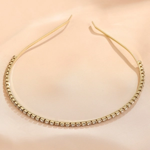 Detail of elegant gold-tone headband decorated with sparkling clear rhinestones on silk