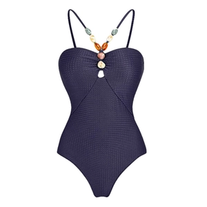Detail of beaded dark purple one-piece swimsuit with honeycomb textured fabric