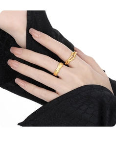 Detailed view of irregular texture gold ring and twig-style diamond band on fingers