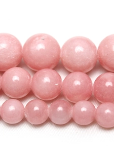 Macro de perles de jade rose en trois tailles montrant texture lisse et dégradé clair