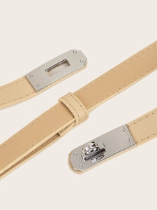 Macro shot of beige slim waist belt featuring a classic silver metal twist lock closure