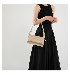 Detail of the chic beige shoulder bag featuring a geometric diamond embossed pattern