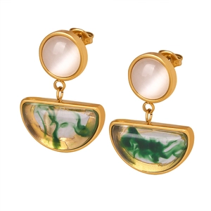 Vintage gold earrings with cat eye stones and green resin pendants on white background