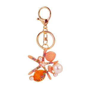 Starfish and seashell keychain with pink rhinestones and pearls on a gold ring
