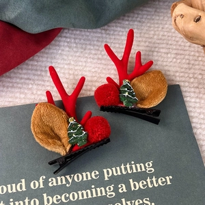 Detail von Weihnachts-Rentier-Haarspangen mit Plüschohren und festlichem Baumdekor
