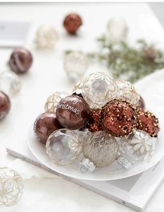Close-up of champagne Christmas ornaments with Merry Christmas text and glitter patterns