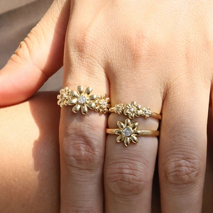 Three-piece set of 18k gold daisy flower open rings with small diamonds on hand