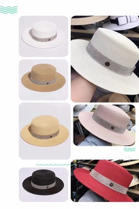 Detail of wide brim straw hats in multiple colors featuring rhinestone M decoration