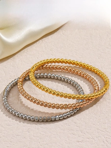 Detail of three-piece beaded bangles in gold rose gold and silver finishes