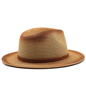 Detail of the gradient brown woven paper straw texture and leather band on a Fedora hat