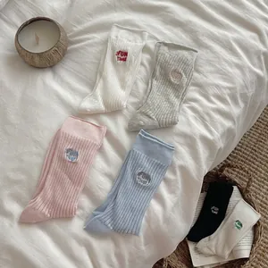 Close-up of vertical ribbed cotton socks with Fun Time embroidery in pastel colors