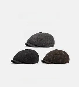 Detailed close-up of herringbone newsboy caps in gray, dark gray, and coffee brown colors