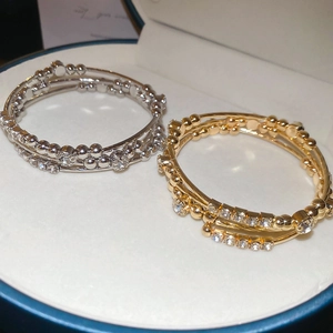 Detail of multi-layer geometric bangles with rhinestones in gold and silver finish
