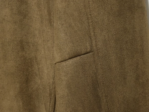 Detailed macro view of high-quality brown faux suede fabric and pocket stitching