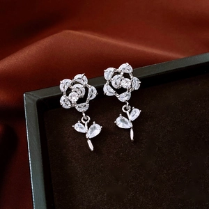 Detail of silver flower earrings with clear cubic zirconia on black velvet jewelry box