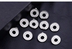 Gros plan de breloques circulaires en cristal sur surface en cuir noir de luxe