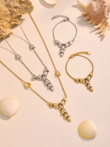 Detailed view of layered leaf pendants with cubic zirconia on gold and silver chains