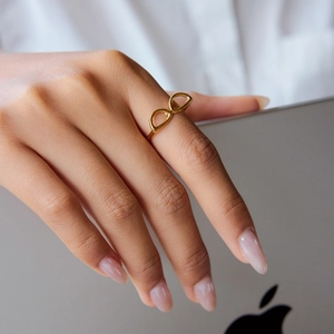 Detail view of 18K gold stainless steel infinity ring on finger for chic daily styling