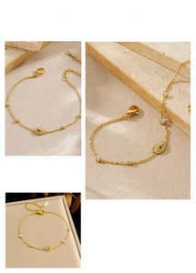 Detailed view of evil eye bracelet with cubic zirconia charms and gold chain links