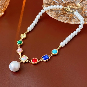 Detail of colorful crystal and pearl拼接 necklace on a dark brown surface