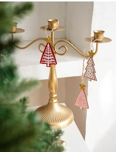 Close-up of wooden Christmas tree ornaments with gold stars on a gold candle holder