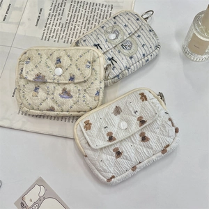 Detailed view of quilted cotton pouches in bear, rabbit, and heart floral patterns