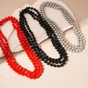 Long multi-layer faux pearl necklaces in red, black, and silver for elegant winter styling